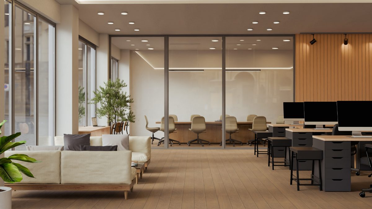 Modern open office space with lounge seating, workstations, and glass-walled conference room
